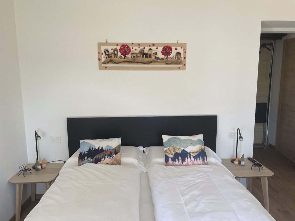 Vista completa della camera con letto matrimoniale, divano letto, cucina e zona pranzo – Il Fiore del Calisio a Villamontagna, Trento