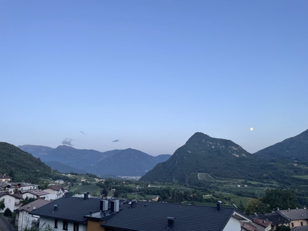 Vista notturna della luna che illumina Pergine Valsugana dall’alloggio Il Fiore del Calisio a Villamontagna, Trento